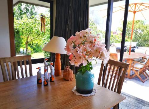 a table with a vase of flowers on top of it at Acacia Bay Lodge- Private Manor with Lake and Garden views in Taupo