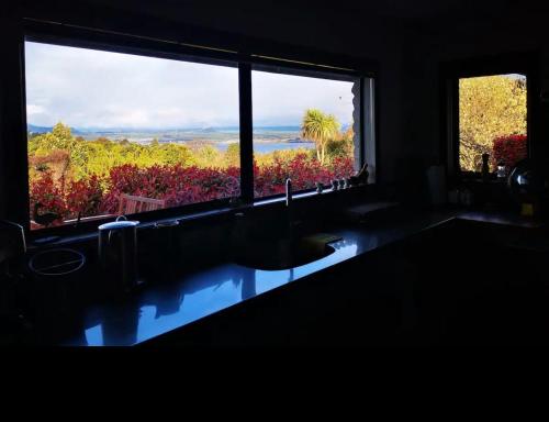 a bathroom with a large window and a large bath tub at Acacia Bay Lodge- Private Manor with Lake and Garden views in Taupo