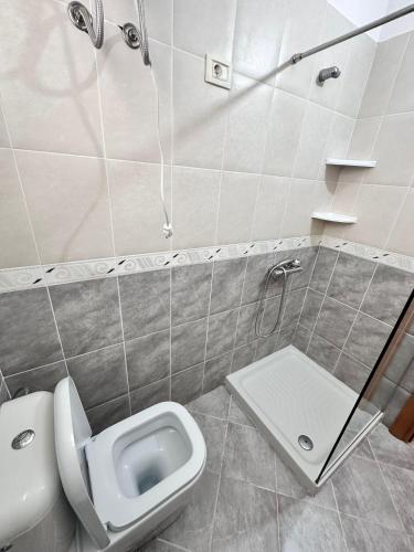Un baño con inodoro, lavabo y ducha. en AURI'S HOUSE, en Vlorë