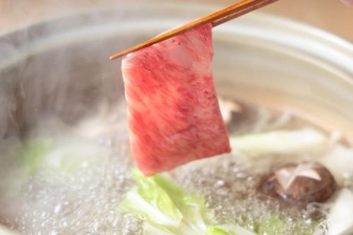a piece of fruit sticking out of a bowl of soup at Beppu Nagomitsuki in Beppu
