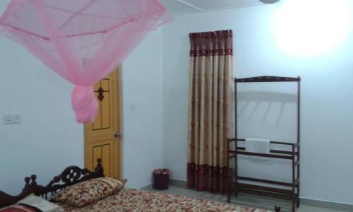 a bedroom with a bed with a pink net at Sea Zone Hotel Nilaveli in Nilaveli