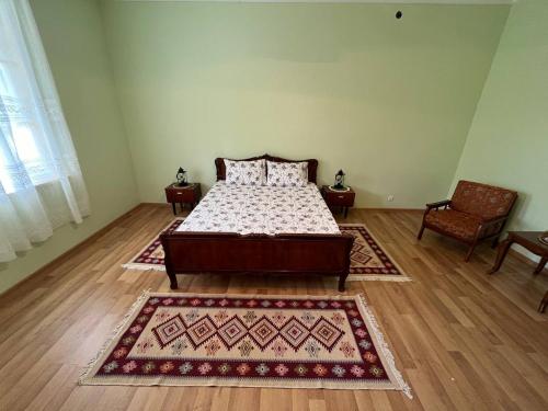 a bedroom with a bed and two rugs on the floor at Kutaisi Countryside Guesthouse and Winery in Kutaisi