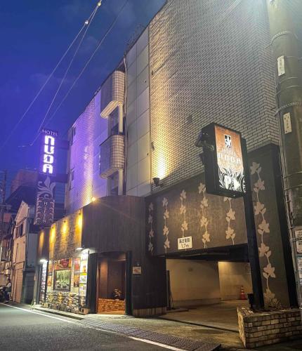 a building on a city street at night at Nuda by H-Seven (Adult Only) in Yokohama