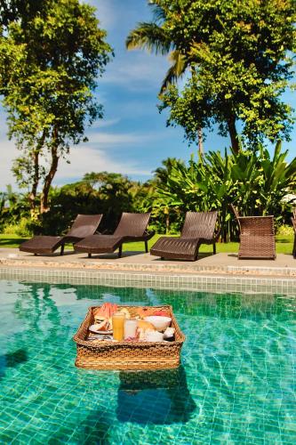 einen Korb mit Speisen in einem Pool in der Unterkunft Pousada Villa Tainá - Arraial d'Ajuda, Bahia in Arraial d'Ajuda