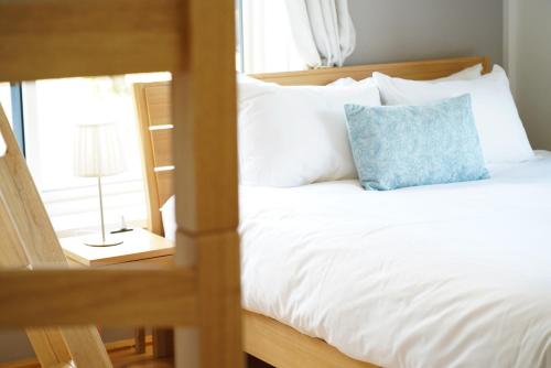 a bedroom with a bed with a blue pillow on it at Togari Inn Suites in Iiyama