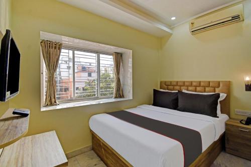a bedroom with a large bed and a window at Collection O Ketan Regency Near Acropolis Mall in Kolkata