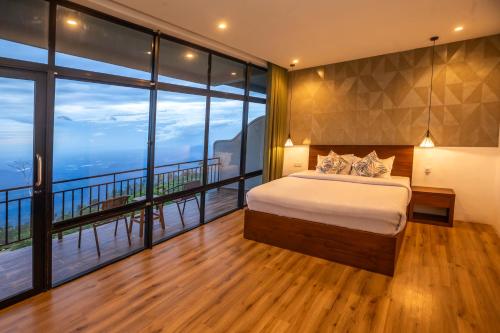a bedroom with a bed and large windows at leisure Mount View in Haputale