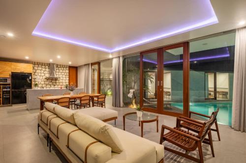 a living room with a couch and a table and chairs at Villa Olea in Uluwatu