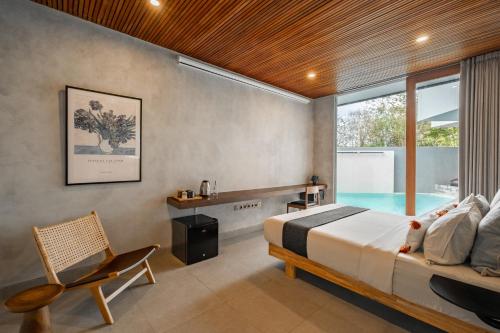 a bedroom with a bed and a swimming pool at Villa Olea in Uluwatu