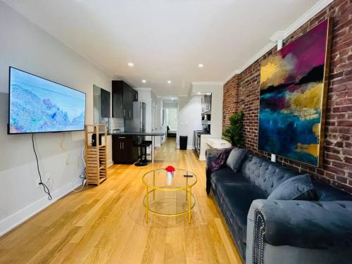 a living room with a couch and a brick wall at Midtown Luxe in New York