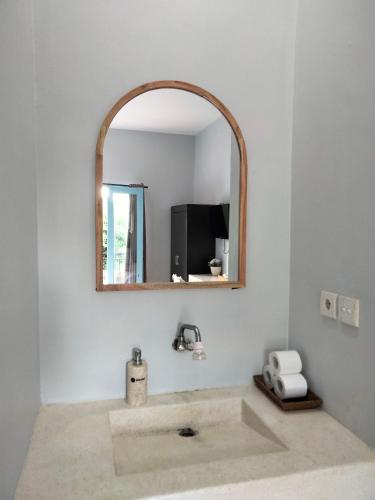 a bathroom with a sink and a mirror at Gatsby Hotel Hostel in Uluwatu