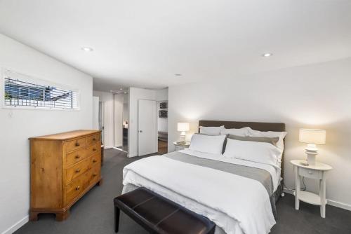 Un dormitorio con una cama grande y una cómoda. en Kaleido Nook Enchanting 3BR Magic on Rugby Street, en Christchurch