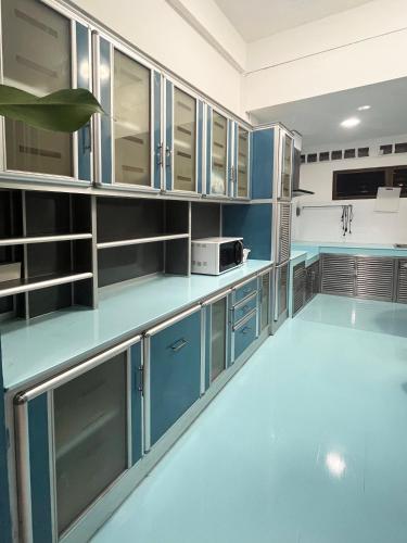 a large kitchen with blue cabinets and appliances at 曼谷市中心素坤逸4卧 泳池别墅 近nana 近Asoka in Bang Kapi