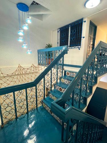 a staircase with blue railings in a house at 曼谷市中心素坤逸4卧 泳池别墅 近nana 近Asoka in Bang Kapi