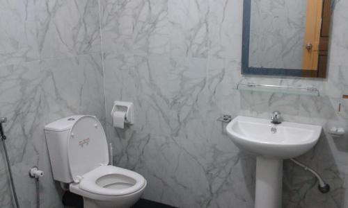 a bathroom with a toilet and a sink at Sea Zone Hotel Nilaveli in Nilaveli