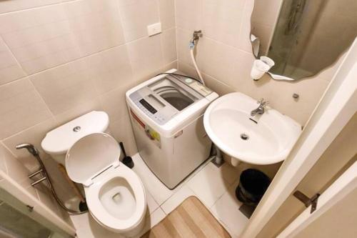 a small bathroom with a toilet and a sink at Boho Beach Vibes 2br Apt 2 in Makati in Manila