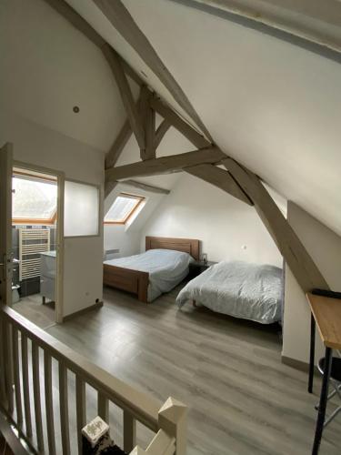 - une chambre mansardée avec 2 lits et un balcon dans l'établissement Petite maison de ville, à Lisses