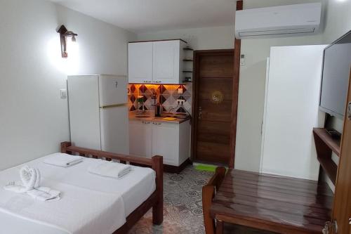 a room with a kitchen with a bed and a table at Finike Apart Orion in Finike