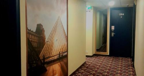 a hallway with a picture of a building on the wall at Hotel Le Paris in Noumea