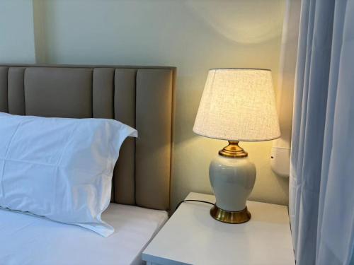 a lamp sitting on a table next to a bed at Apamet Hotel Sukhumvit 55 in Khlong Toei
