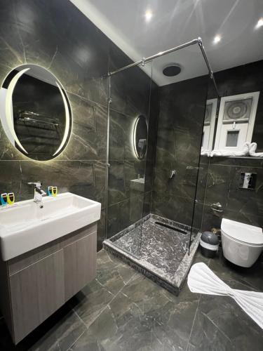 a bathroom with a shower and a sink and a toilet at Onyx Pyramids Boutique Hotel in Cairo