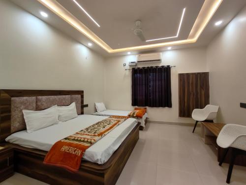 une chambre avec un lit, une table et des chaises dans l'établissement BRiJWAS DHAM, à Vrindavan