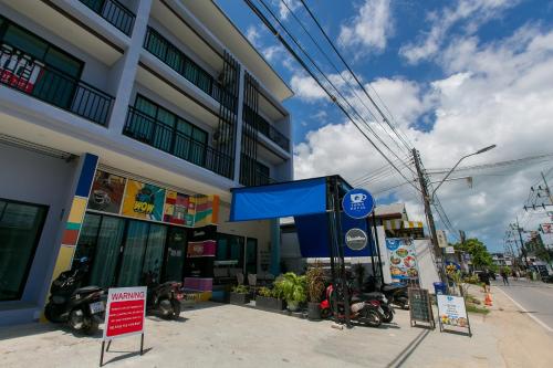 a gas station with motorcycles parked in front of a building at Wow Academy & Stay Soi Tai-Aed 3B in Ban Suan