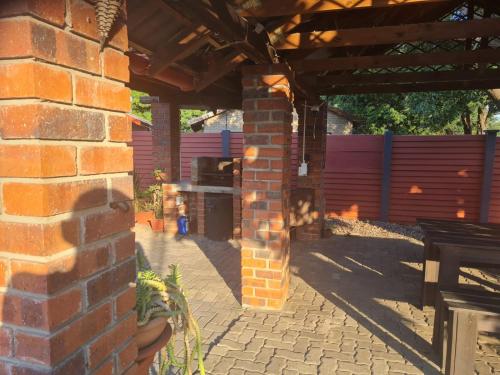 an outdoor patio with a brick wall and a grill at Cassiandra Place unit 3 in Richards Bay