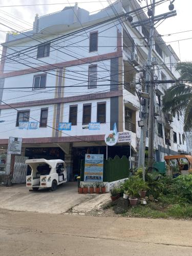 a building with a car parked in front of it at Dante's Hideaway Guest House in Boracay