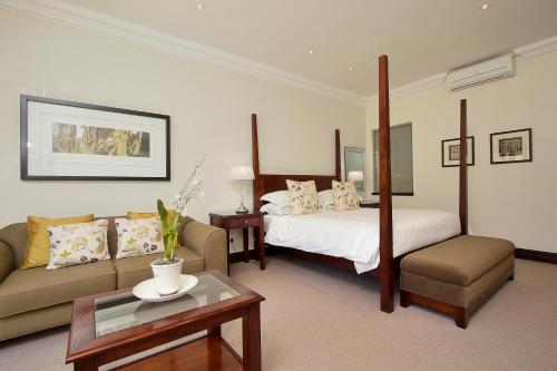 a hotel room with a bed and a couch at The Syrene Boutique Hotel in Johannesburg
