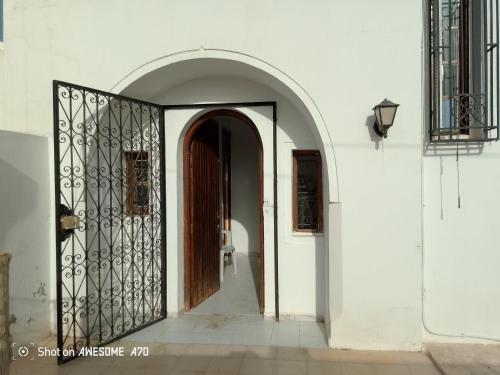 an entrance to a white building with a wooden door at Maison La rose 1 in Mezraya