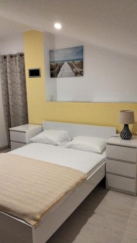 a bedroom with two beds and a yellow wall at Special Room Sofia's Happy House- Almodôvar Ourique - Room 3 in Aldeia dos Fernandes