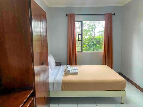 a bedroom with a bed and a window at Albergo Hotel in Baguio