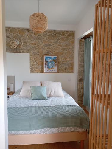 une chambre avec un lit et un mur en pierre dans l'établissement A casettuccia santu petru, à Santo-Pietro-di-Venaco