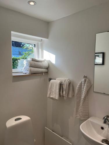 a bathroom with a sink and a toilet and a window at Beach Guest House in Greve