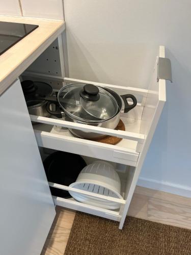 a kitchen drawer with a pot and pans on it at Beach Guest House in Greve