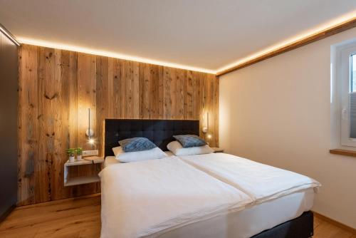 a bedroom with a large bed with wooden walls at Haus Rass in Kirchberg in Tirol