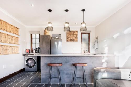Una cocina con una barra con dos taburetes. en Avemore Time Out - full power back up, en Stellenbosch