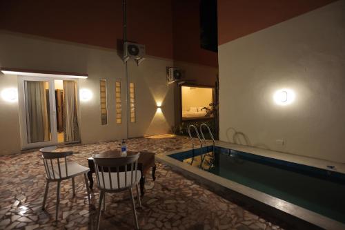 a room with a swimming pool and a table and chairs at PALM PARADISE Beach Resort in Puducherry