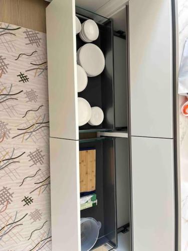 a cupboard with white plates in a room at Luxury lakeside home Geneva Lausanne in Rolle