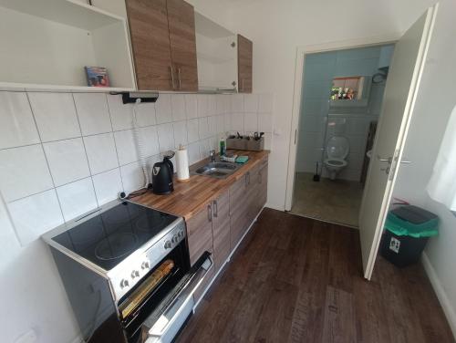 a small kitchen with a stove and a sink at GranseeHOSTEL in Gransee