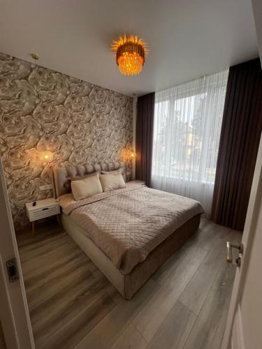 a bedroom with a large bed and a stone wall at Chic Residence apartament 3 in Šiauliai