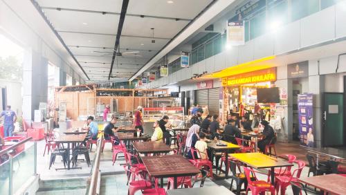 a group of people sitting at tables in a restaurant at Homestay Vista Alam in Shah Alam