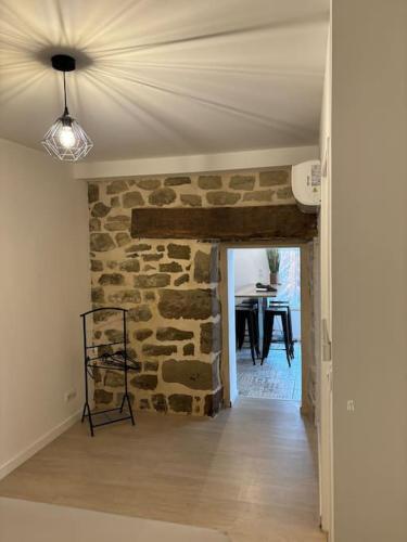 - un salon avec un mur en pierre et un plafond dans l'établissement Jolis logements brivistes 6, à Brive-la-Gaillarde