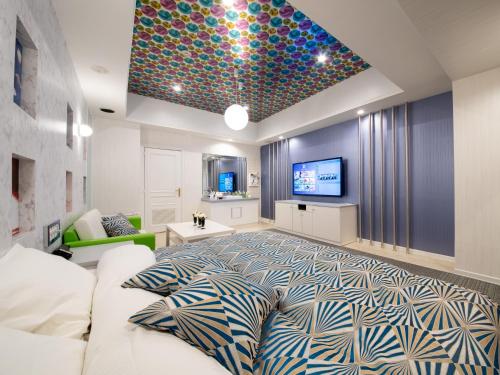 a living room with a large bed and a tv at アルバニア in Matsuyama