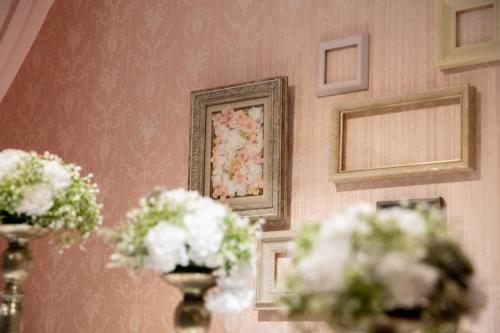 a room with flowers in vases on a wall at アルバニア in Matsuyama
