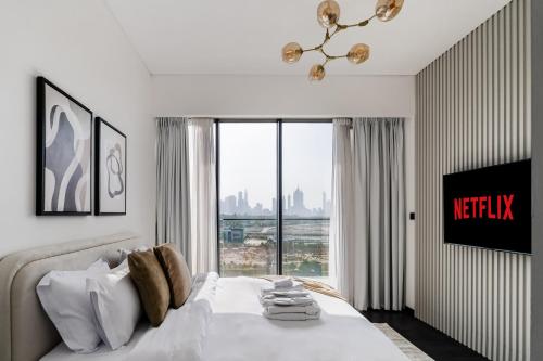 a bedroom with a white bed with a large window at Stylish 1BR with Dubai Skyline & Burj Khalifa View in Dubai