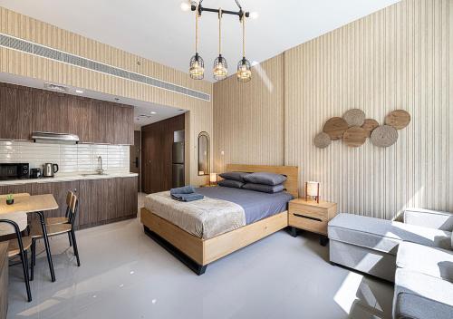 Un dormitorio con una cama y una mesa y una cocina. en Apartment With Private Garden - Luxe Gold, en Sharjah
