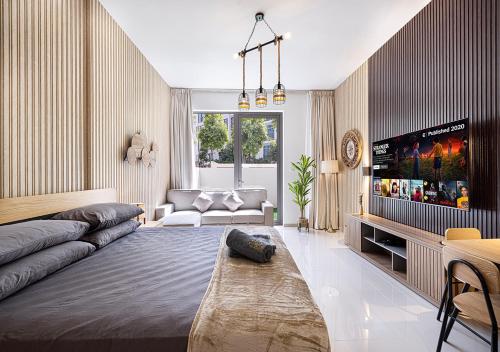 a living room with a couch and a flat screen tv at Apartment With Private Garden - Luxe Gold in Sharjah