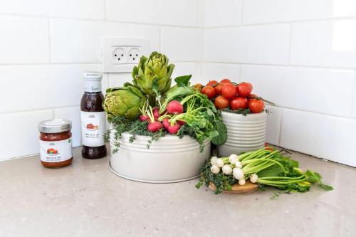 three buckets of vegetables sitting on a counter withbid at Luxury 4 Bedroom With Amazing View In Ramat Sharet Bayt Vegan in Jerusalem